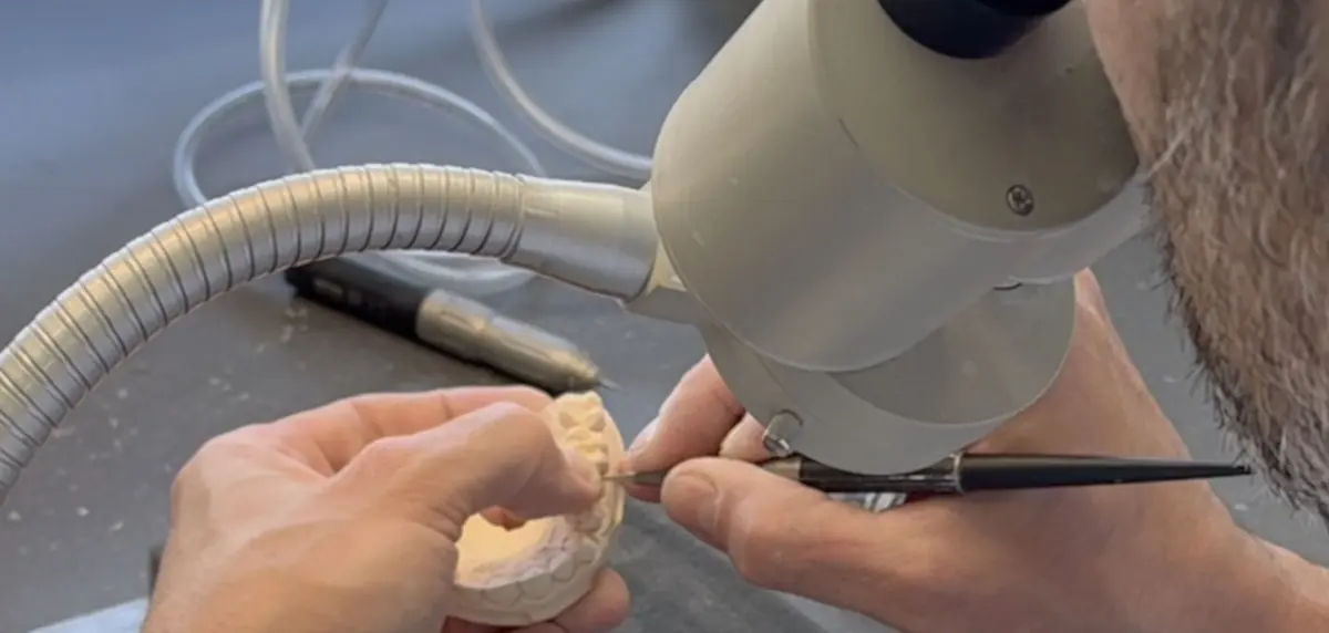 Cleaning the margins of a stone model under the microscope